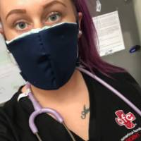 A healthcare professional wearing a mask made by PCEC volunteers